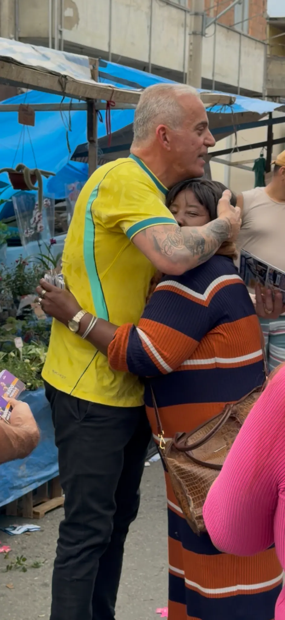 Dinho do Canella abraçando um morador